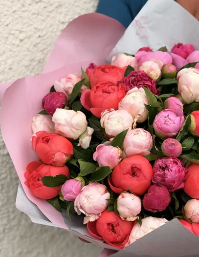 Gros plan sur bouquet rond etgénéreux, composé de pivoines roses et de pivoines rouge